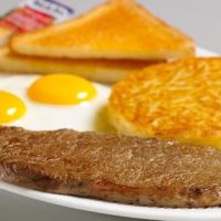 over easy eggs, steak, hashbrowns and toast